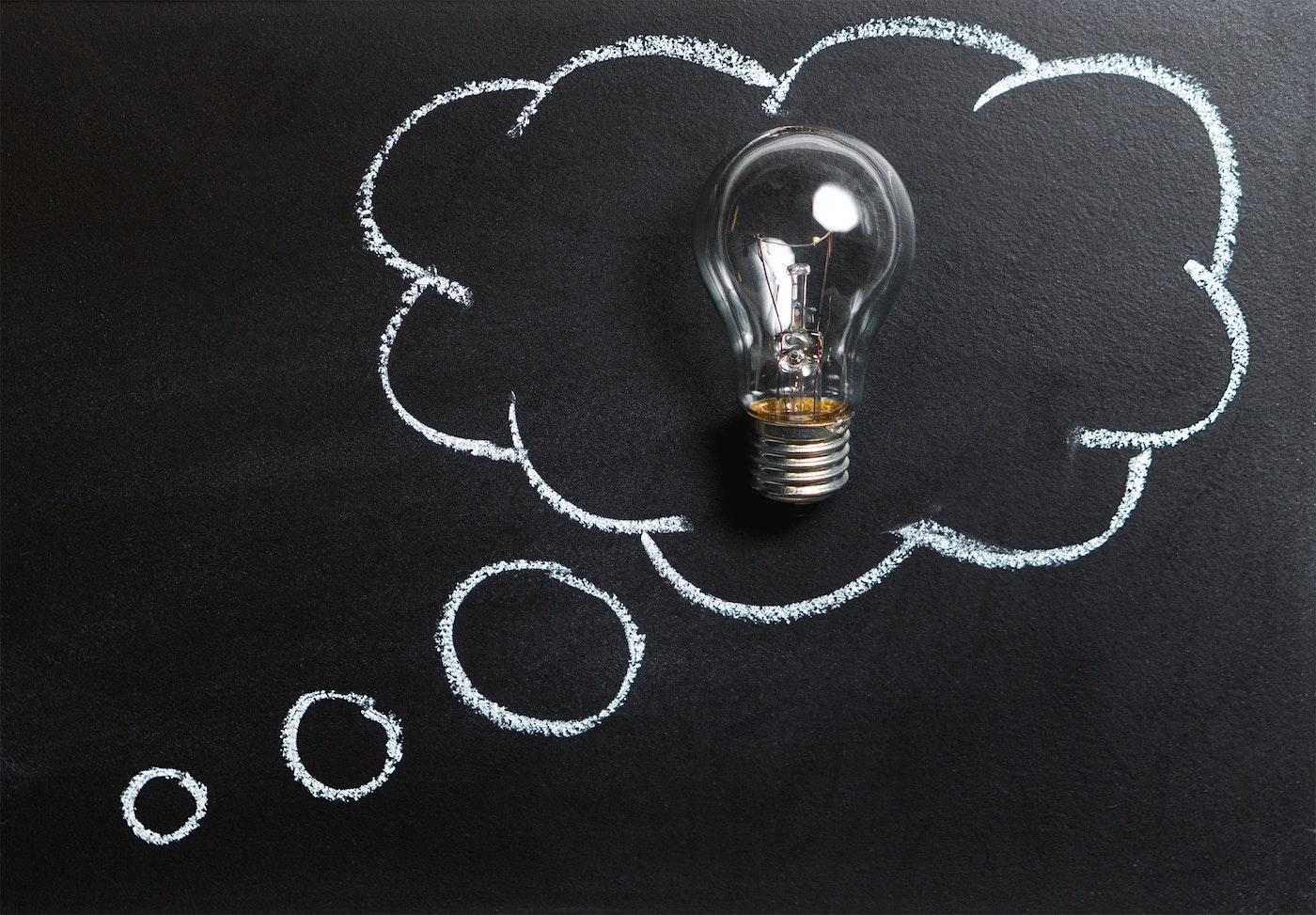 Image of thought bubble drawn in chalk with lightbulb in the middle. Meant to symbolize intellectual property.