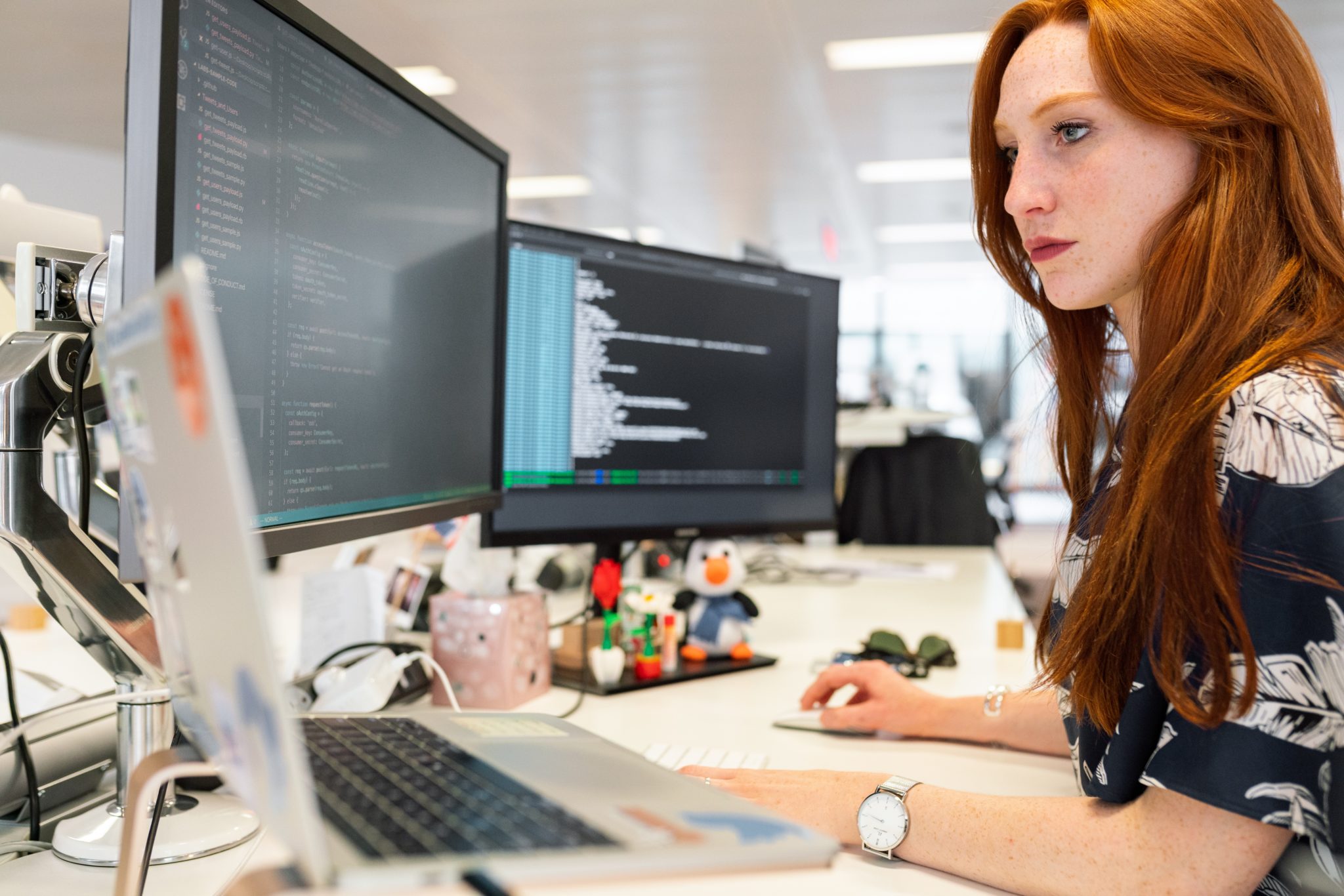 A picture of a data scientist reviewing three monitors as they dive into unstructured data.
