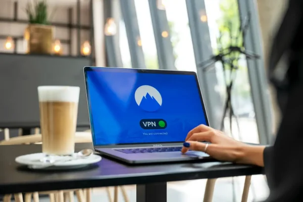 woman using a vpn on her laptop in a cafe
